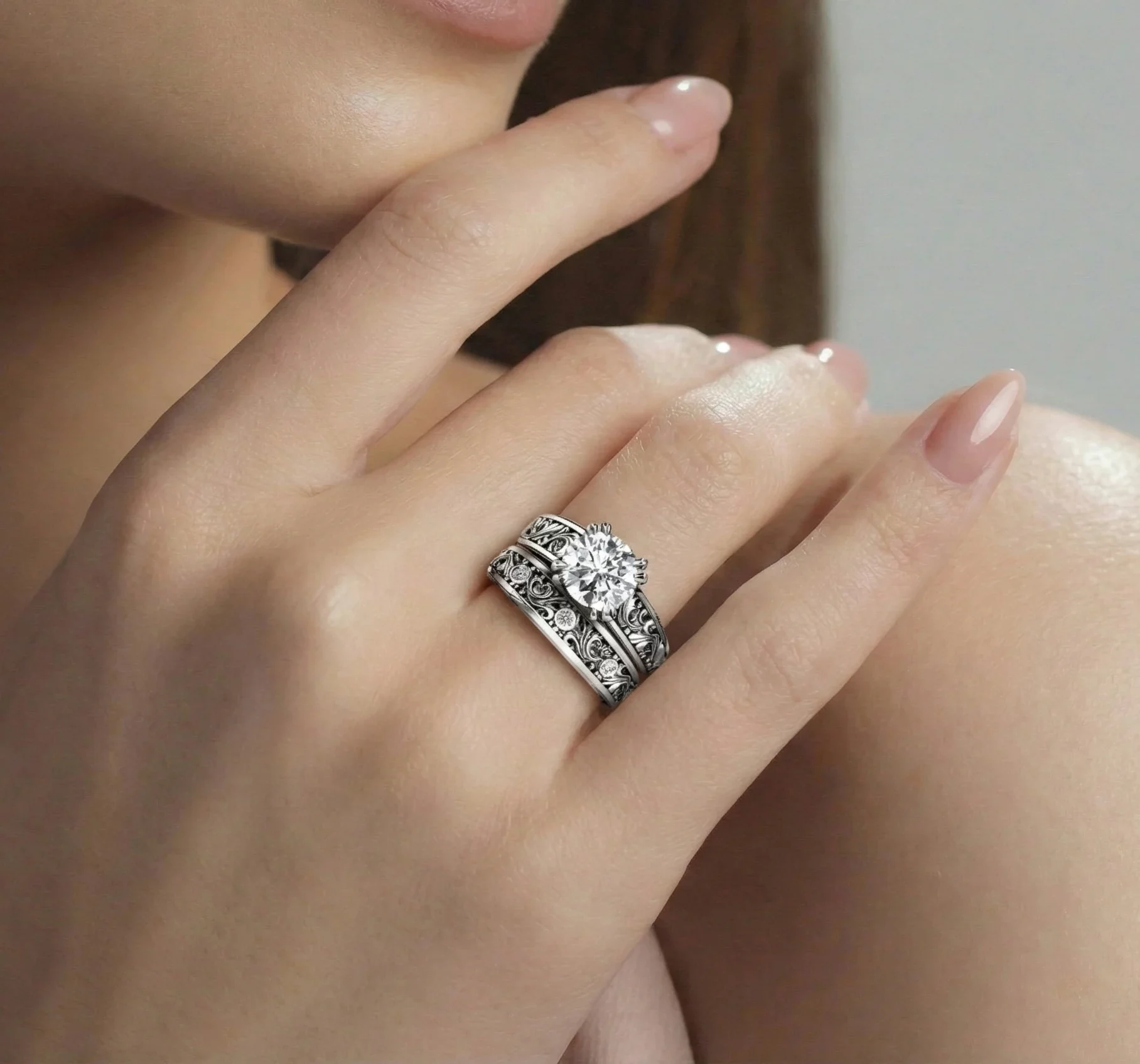 Vintage filigree scroll moissanite bridal set worn together on a woman's hand.