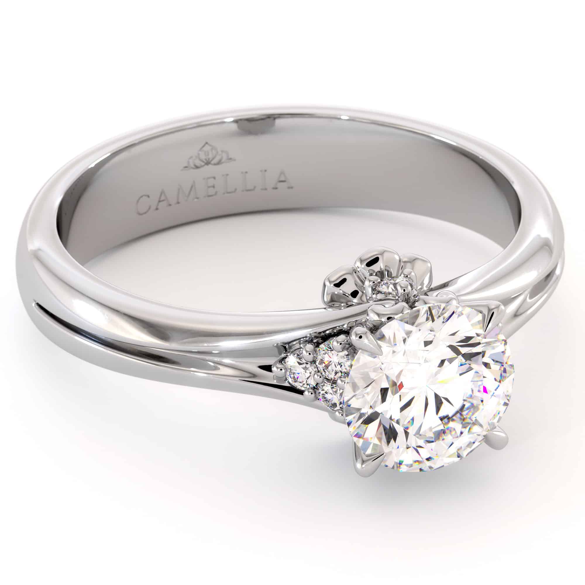 CL-0007A — White Gold, angled view White gold solitaire seen at an angle, showing the polished gallery and the Camellia mark inside the band