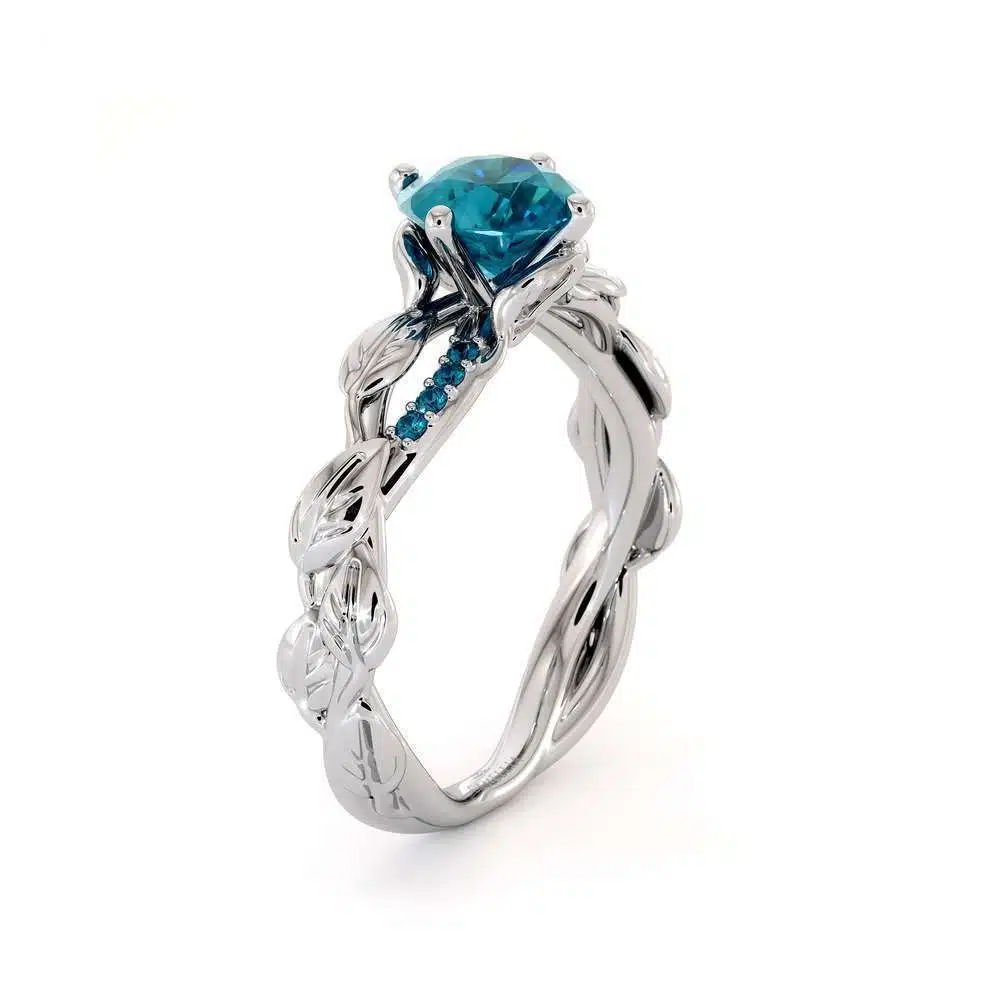 Angled View Azure Leaf Twisting Ring An angled view of a leaf-themed engagement ring featuring a blue diamond and twisting white gold band.