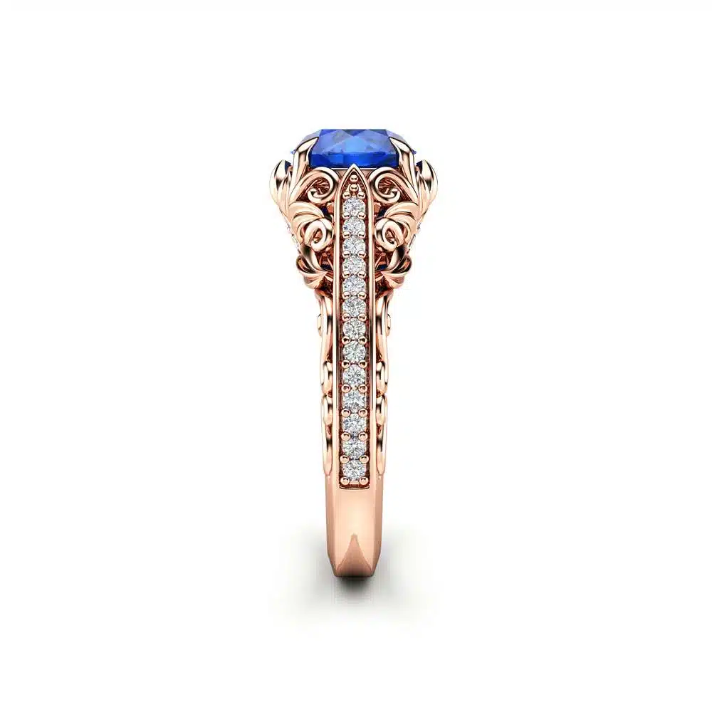 AL-0055C — Rose Gold, profile view of scrollwork Side profile of the rose gold sapphire ring, showing the flaring scrollwork gallery and pave diamond column beneath the stone