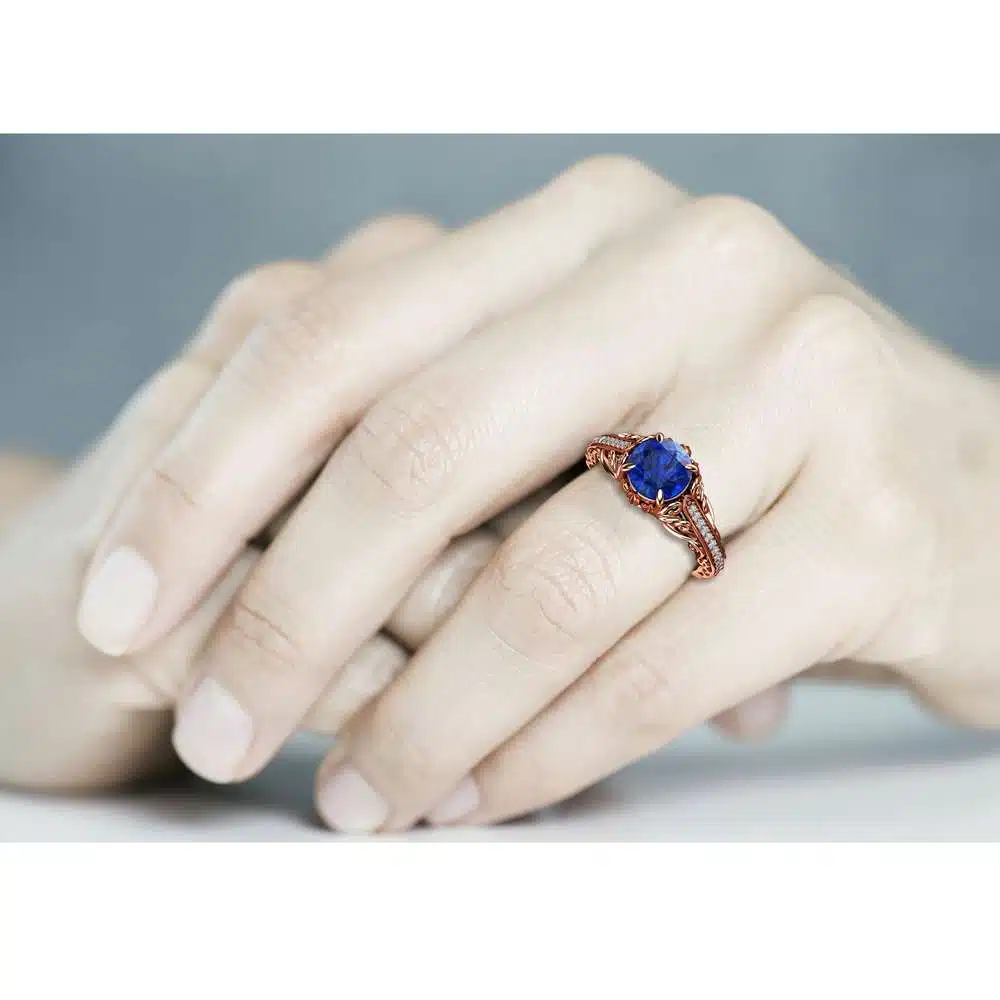 AL-0055C — Rose Gold, worn on hand Rose gold blue sapphire engagement ring worn on the hand, fingers resting together
