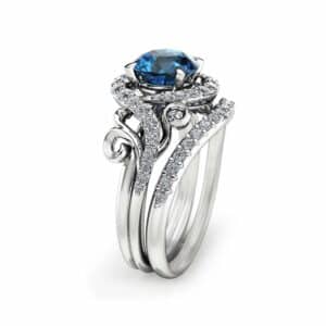 An angled side view of a swirl blue diamond bridal set featuring a halo setting and pavé-set bypass bands.
