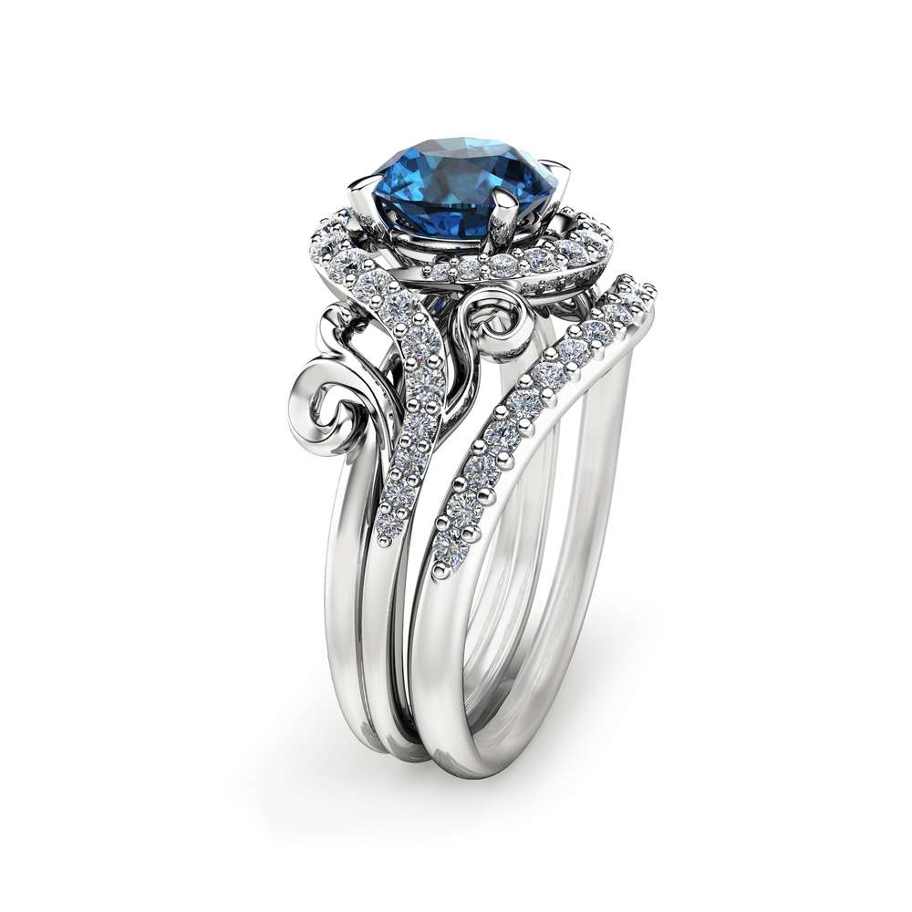 Angled View Swirl Blue Diamond Bridal Set An angled side view of a swirl blue diamond bridal set featuring a halo setting and pavé-set bypass bands.