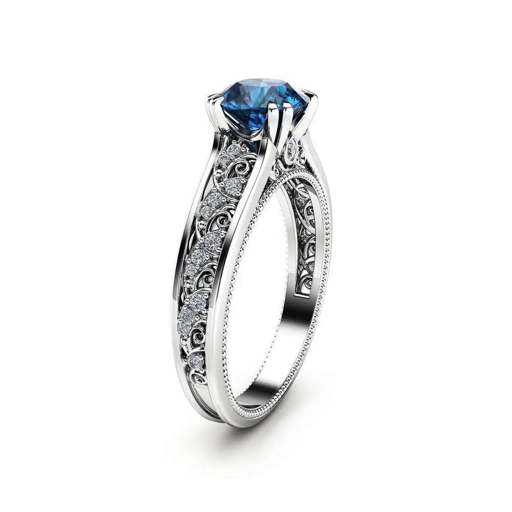 Frontal View Ethereal Azure Vintage Ring Direct frontal view of a round blue diamond vintage ring with milgrain and side diamond accents.