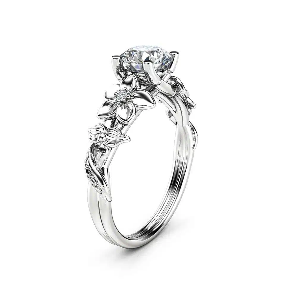 Angled View Botanical Leaf Diamond Ring An angled view of a leaf-themed engagement ring with a round diamond center and sculpted branch band.