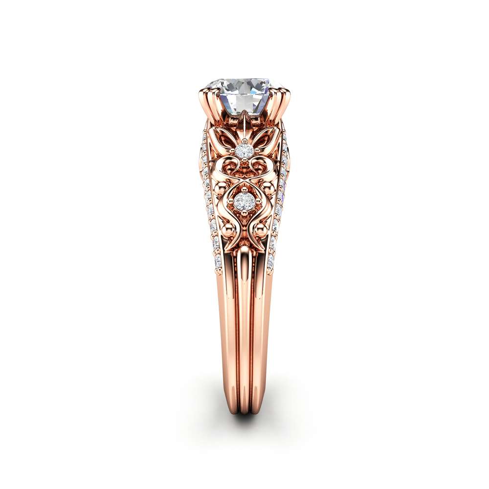Profile through the rose gold ring, the pave shoulders splitting beneath the raised moissanite