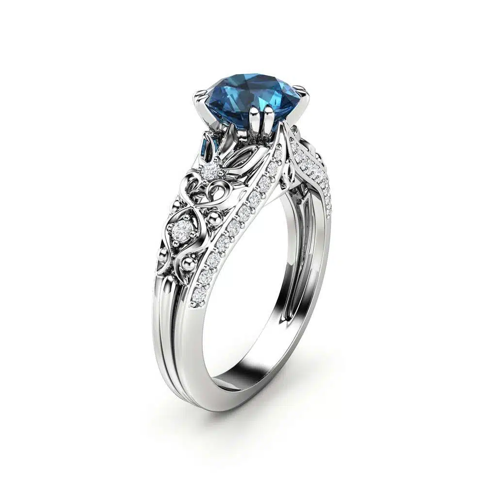 Angled View Art Deco Azure Filigree Ring An angled view of an Art Deco ring with a blue diamond and white gold filigree.
