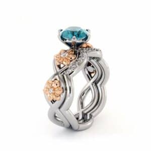 Frontal view of a blossoming blue diamond bridal set with sculpted flowers and clear diamond accents.