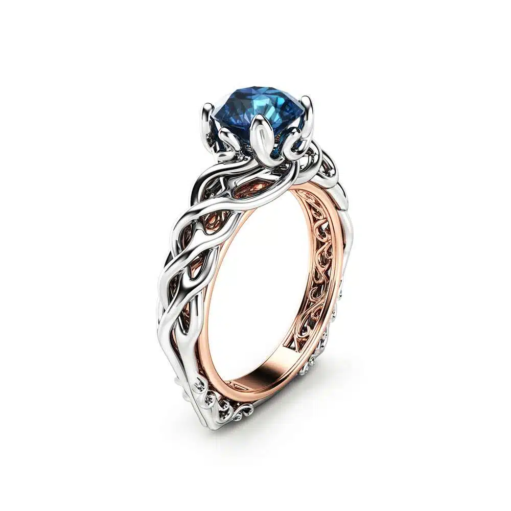 An angled view of a braided Celtic engagement ring with a blue diamond center.
