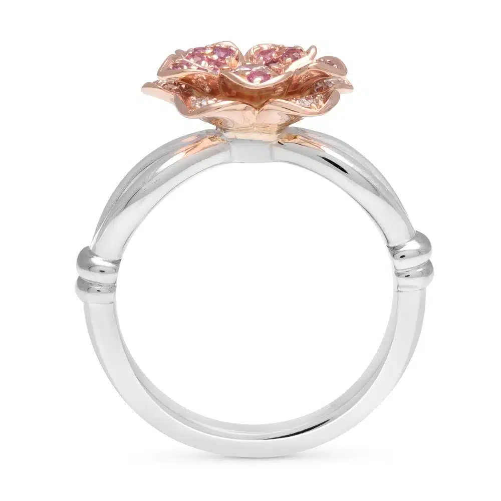 SF-0009A — White and Yellow Gold, styled on wood Two-tone daisy ring photographed on a pale wooden surface, gold pave petals catching the light